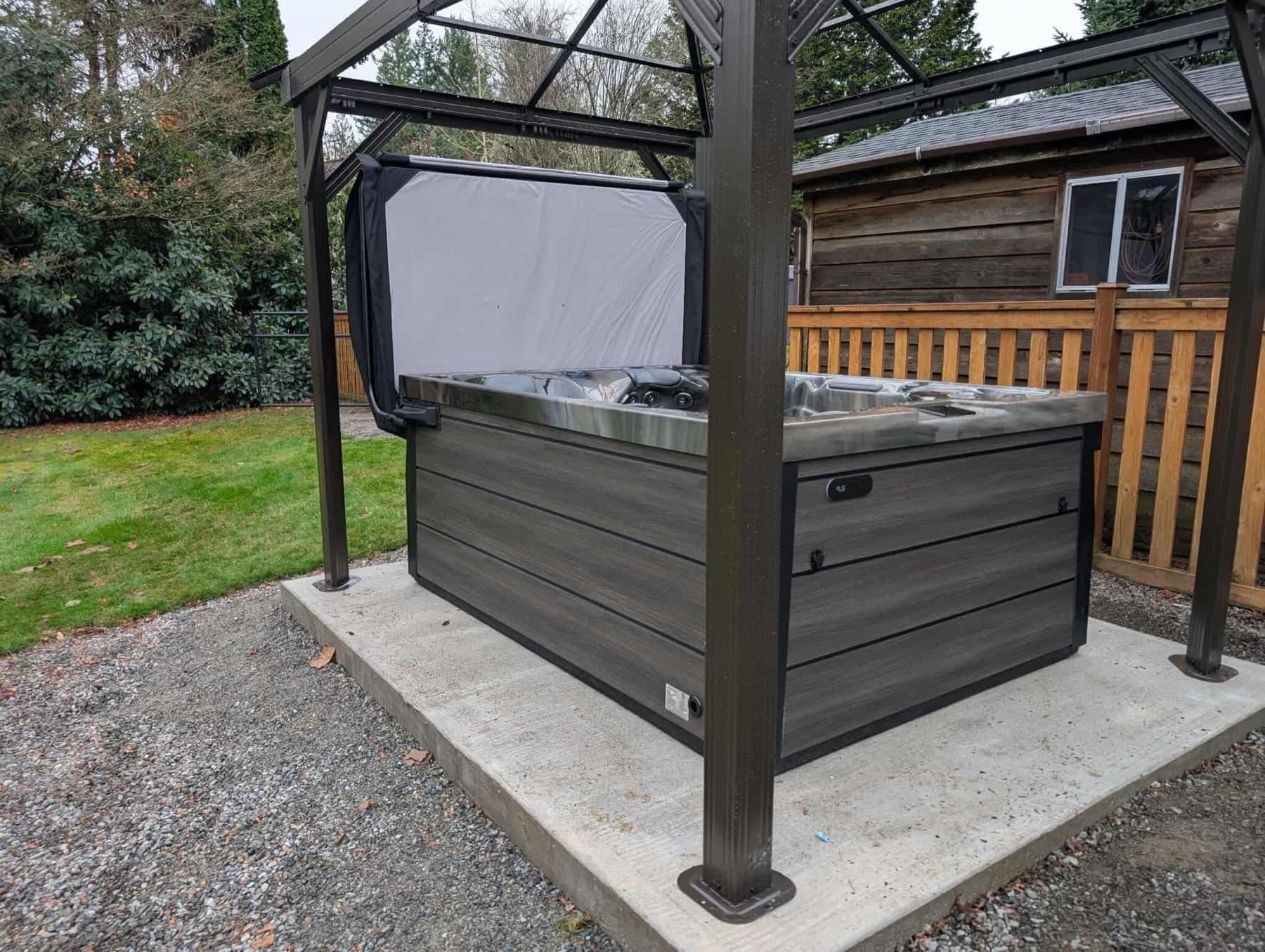Hot tub under a metal gazebo on a gravel pad