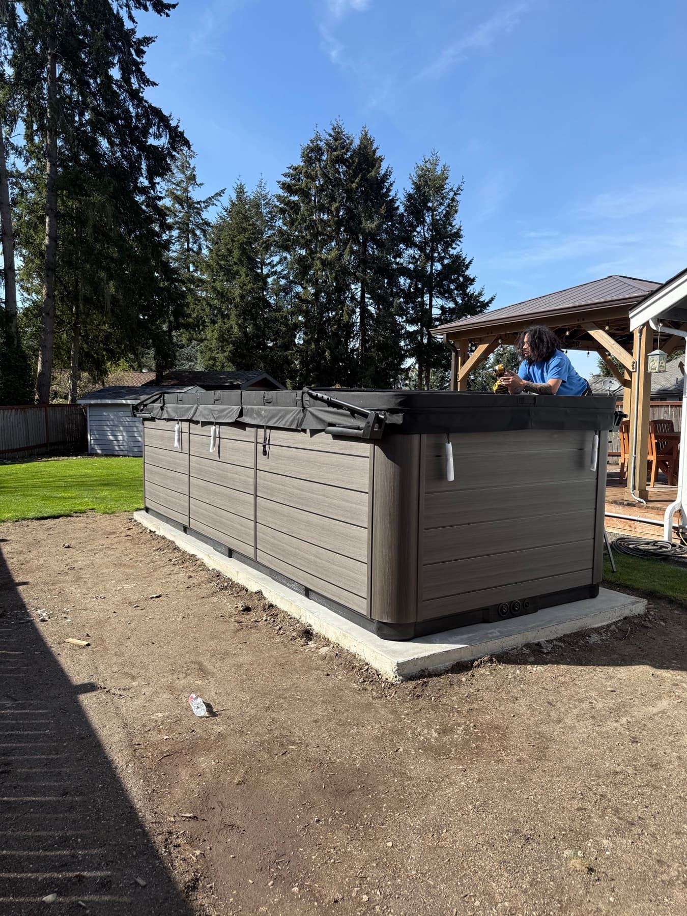 Hot tub on a paver base in an open backyard