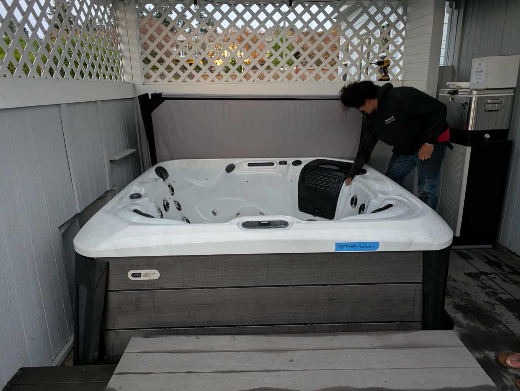 Hot tub tucked into a deck corner behind a lattice screen