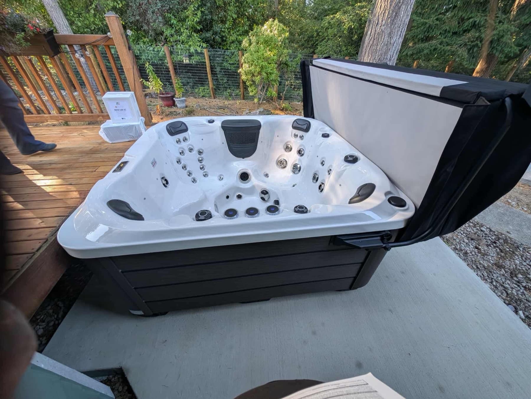 Hot tub with the cover open on a wood deck