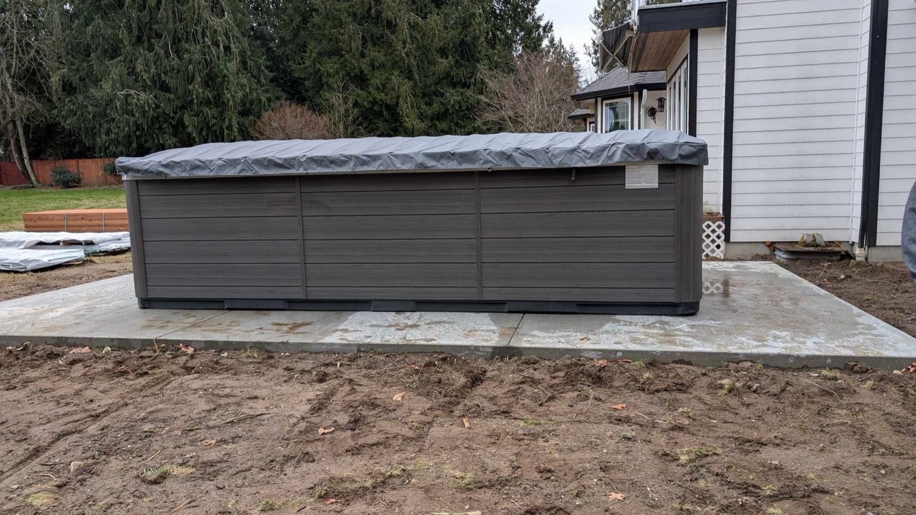 Hot tub on a new concrete pad in a graded backyard