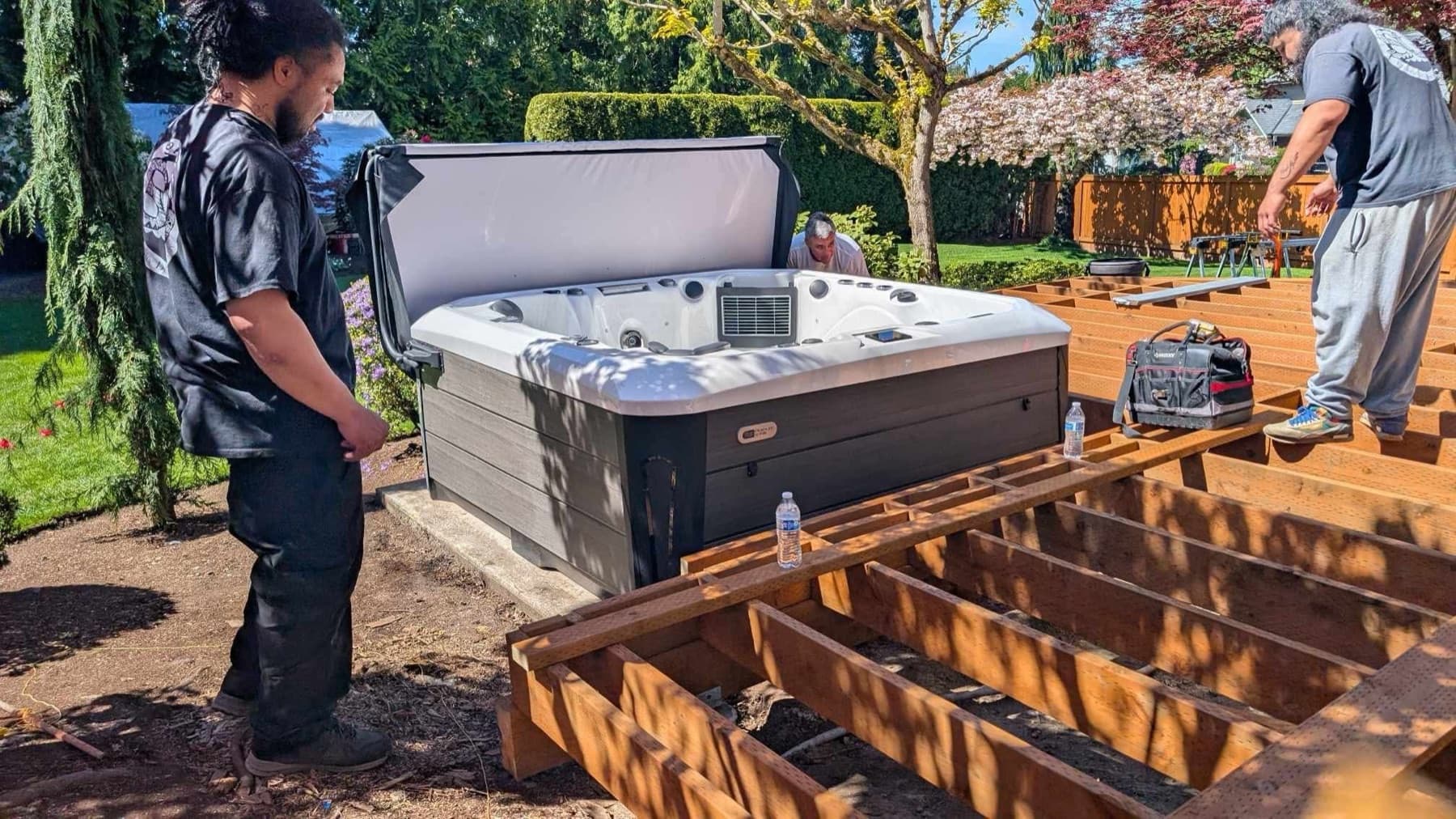 Crew positioning a hot tub over a new deck frame