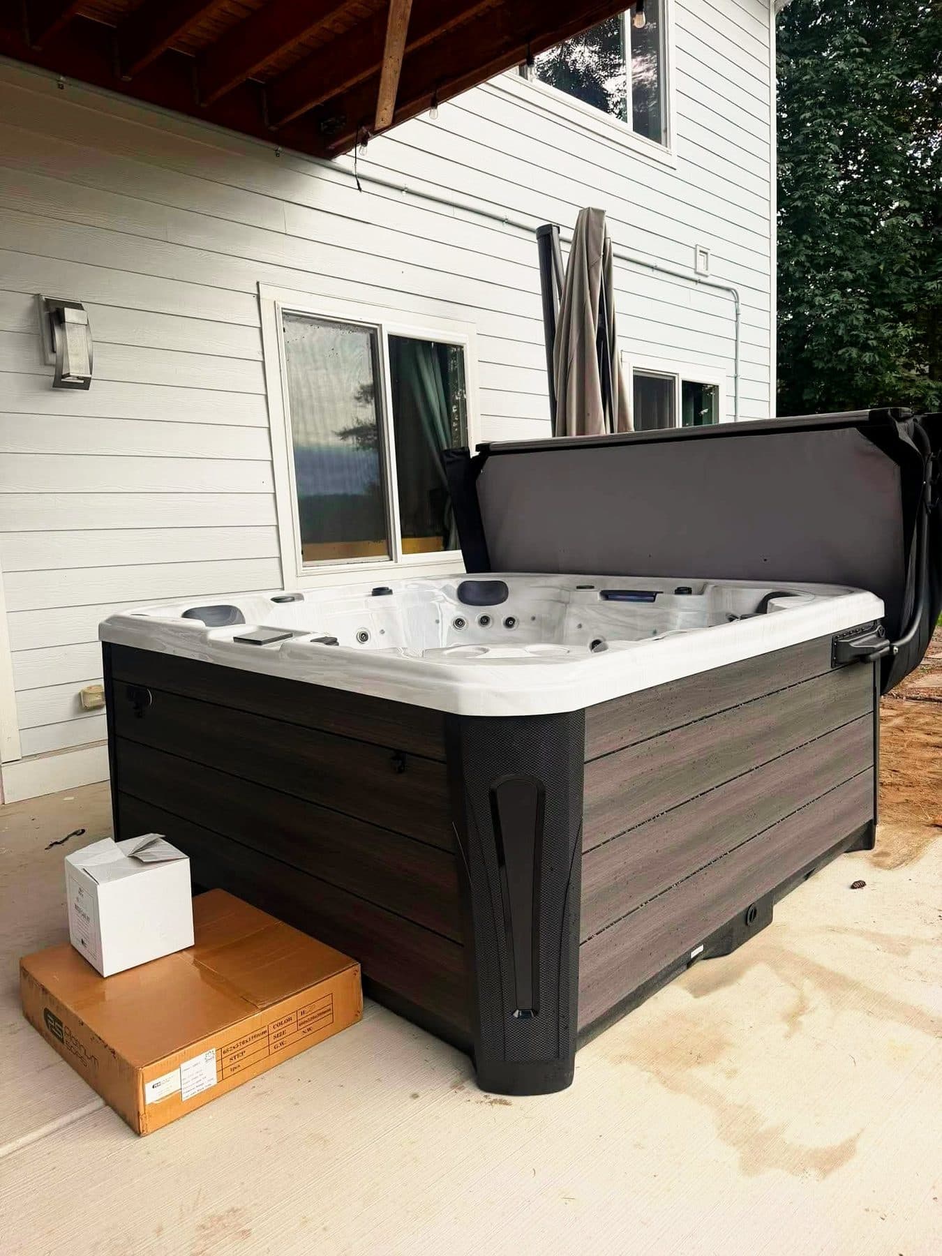 Hot tub with the cover open on a covered patio