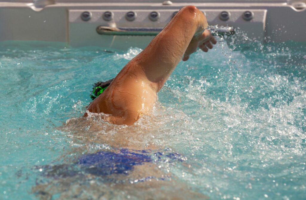 man swimming in a swim spa