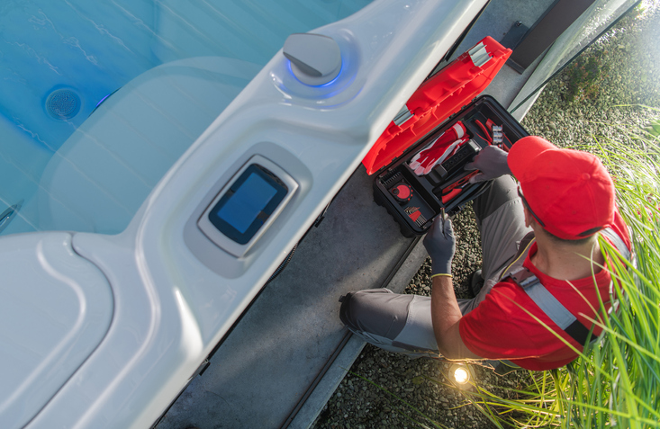 hot tub technician working on fixing hot tub parts